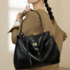 A woman styling the black leather underarm bag with a professional blazer.
