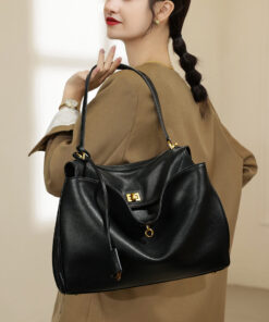 A woman styling the black leather underarm bag with a professional blazer.