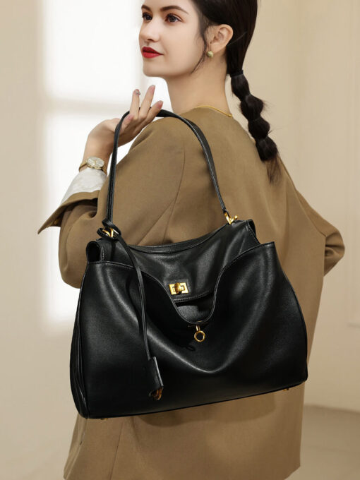 A woman styling the black leather underarm bag with a professional blazer.