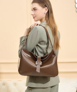 Side profile of a woman carrying a glossy brown leather hobo bag over her shoulder, showcasing its elegant shape and buckle detail.