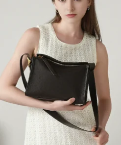 Slouchy Leather Hobo Bag in black pebbled calfskin held by a model, featuring an adjustable strap and gold-tone hardware.